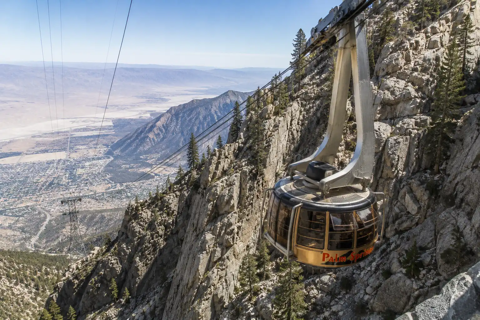 Palm Springs Aerial Tramway car ascending the steep cliffs of Chino Canyon with the desert valley far below